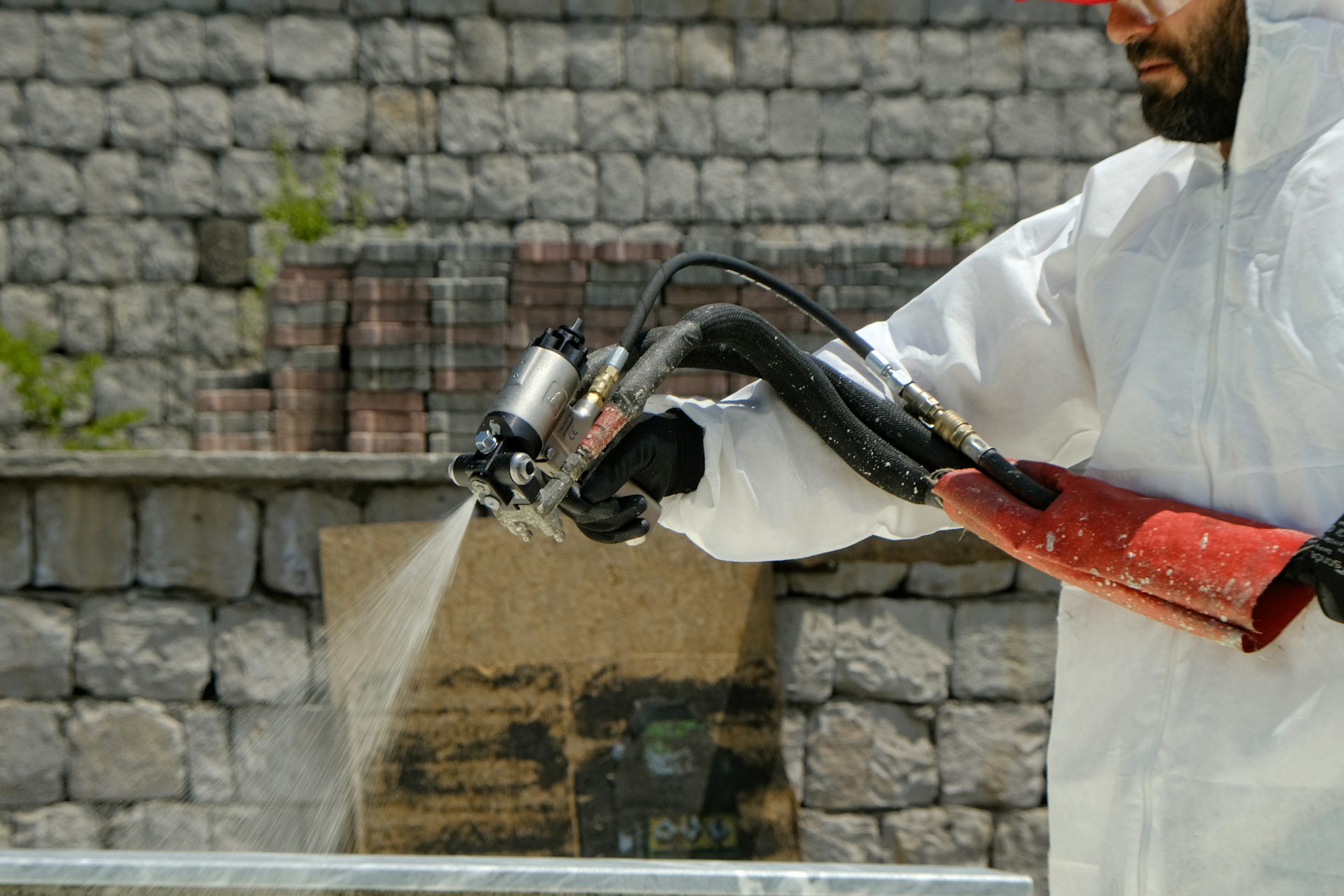 Specialist in a protective coverall dampening materials during asbestos removal in Camberley